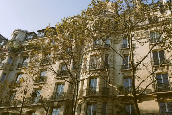 The front of a tall white tenement building.