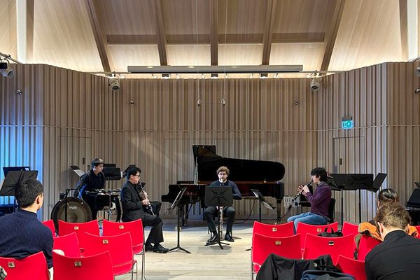 A small ensemble perform in a quiet recital hall.