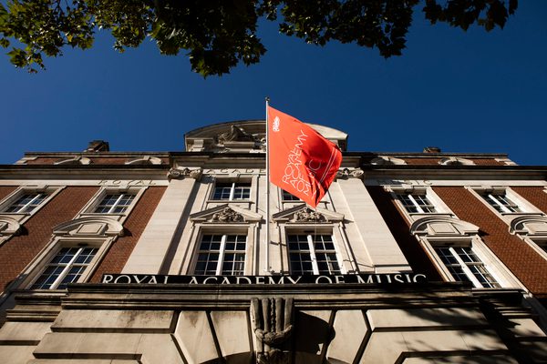The Academy flag flying against a clear sky at the front of the main building.