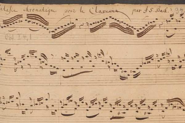An extract of an old music manuscript - dark brown hand written notes on brown aged paper.
