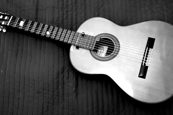 An augmented guitar with magnets on the fretboard lies on a dark cloth.