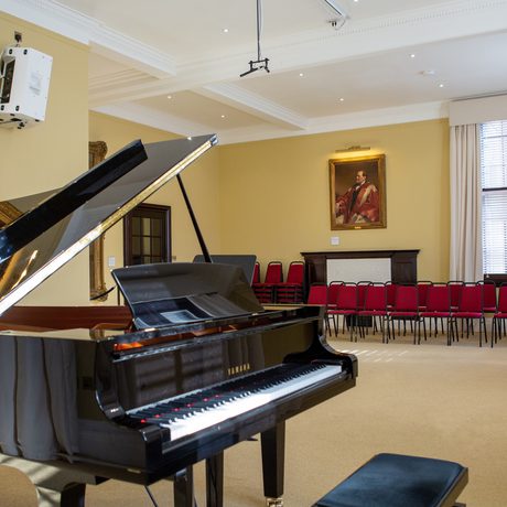 A small recital room, from behind the piano keyboard.