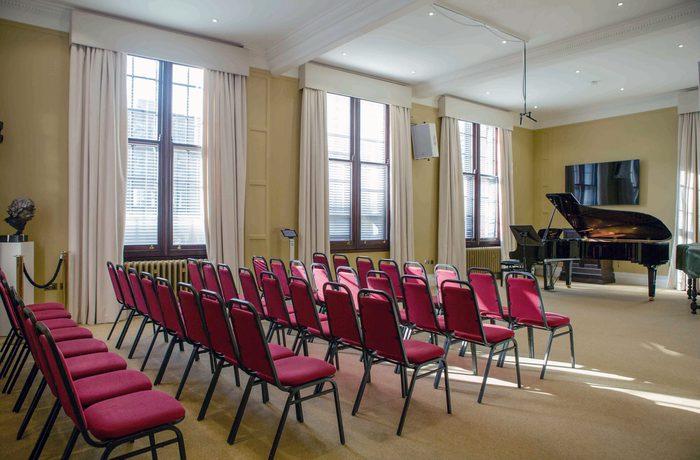 A small room with a piano setup for an intimate recital.