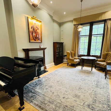 A large teaching room with a piano.