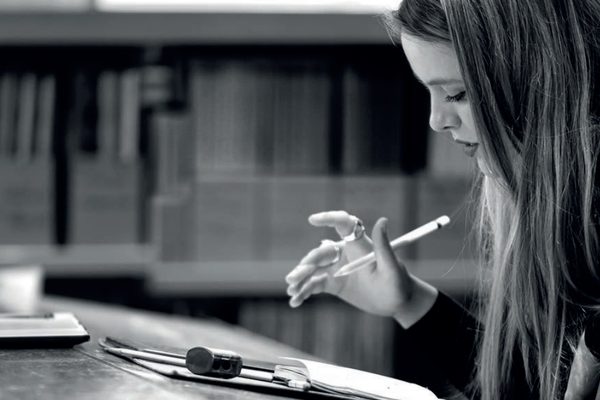 A student takes notes at a desk.