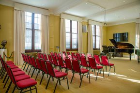 View of the Forsyth Room with full seating setup, with a grand piano in the performance space.