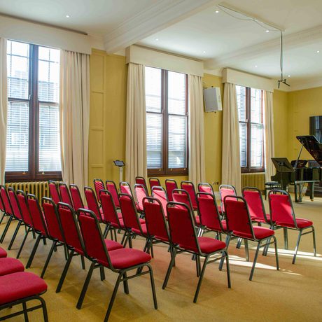 View of the Forsyth Room with full seating setup, with a grand piano in the performance space.