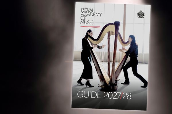 An inset of the front page of a printed guide, with an musicans across the front.