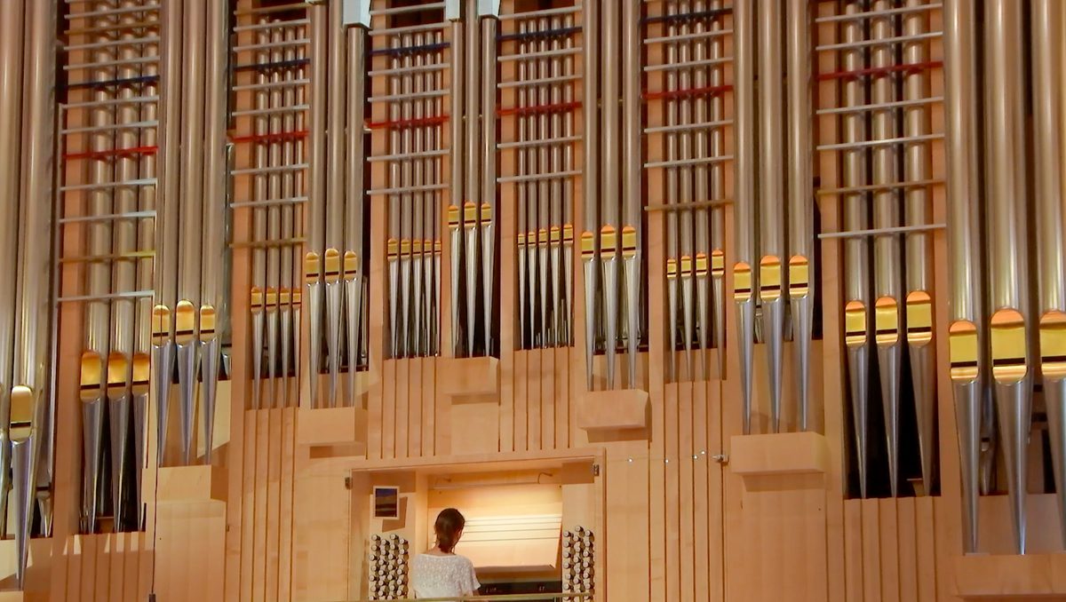 An organist plays a large pipe organ.