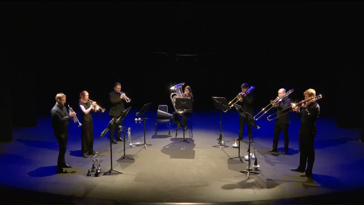A brass ensemble perform on stage.
