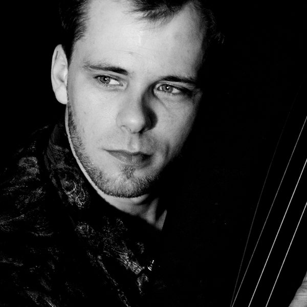 Stylised monochromatic portrait headshot of Alexander Boldachev holding a harp staring off camera