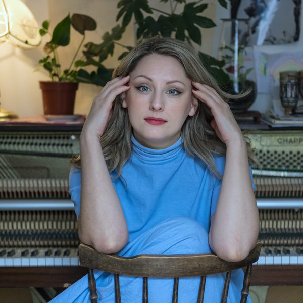 Alice Zawadzki sits backwards on a chair, hands against head.