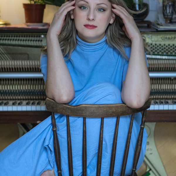 Alice Zawadzki sits backwards on a chair, hands against head.