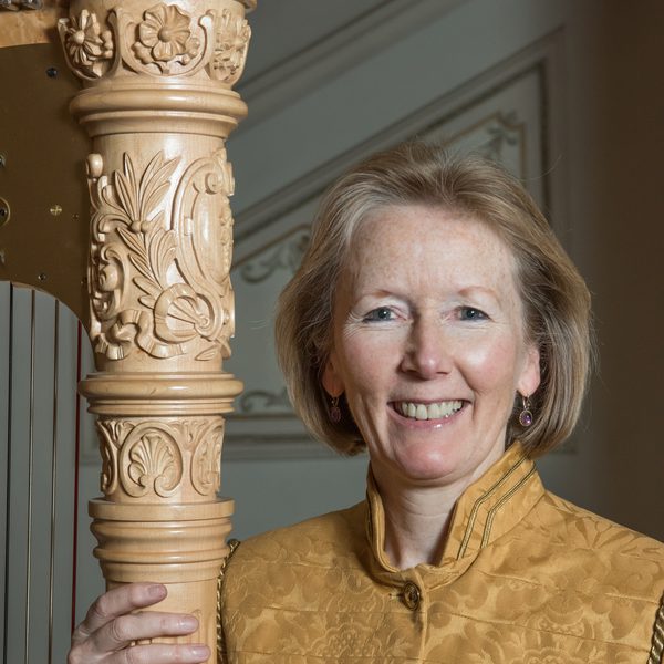 Alison Martin stands next to a harp column.