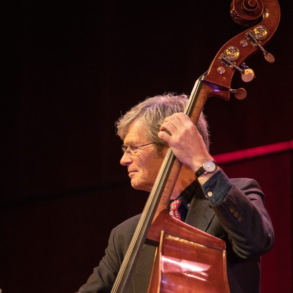 Alyn Shipton holds a double bass in concert.