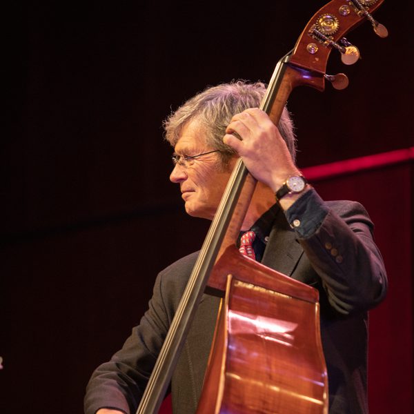 Alyn Shipton holds a double bass in concert.
