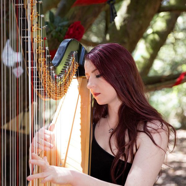 Amy Turk playing harp outside.