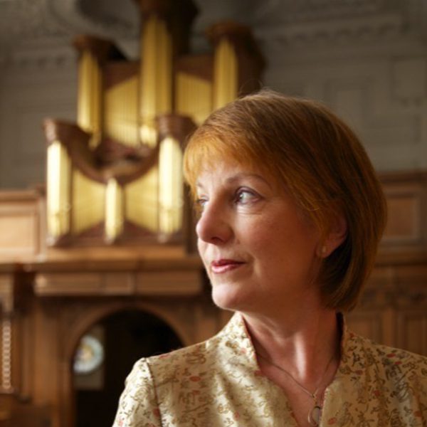 Anne Page looks thoughtfully to the side, backed by a fireplace.