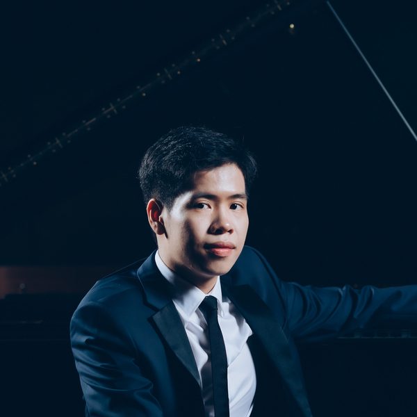 Anson Wong sits at a piano keyboard, looking to camera.