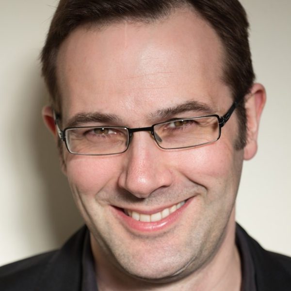 Christopher Glynn smiles to camera.