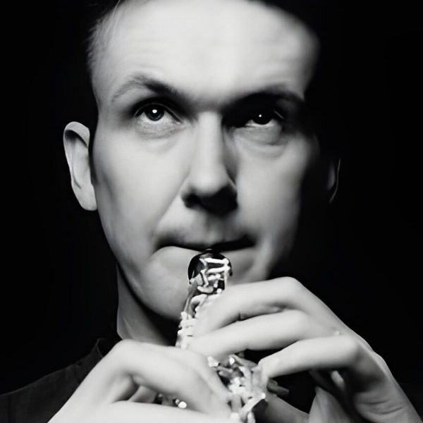 Christopher Cowie plays a clarinet, looking up.