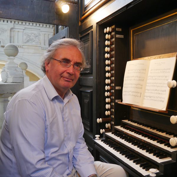 David Ponsford sits at an organ keyboard, facing camera