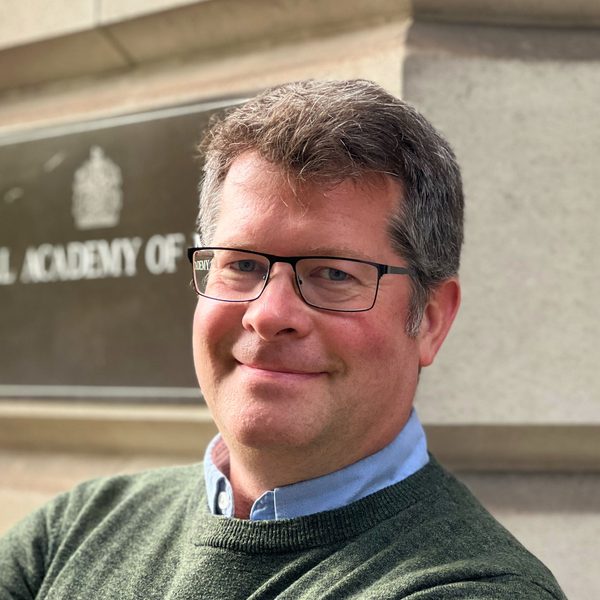 David Pyatt stands outside the Academy, facing camera.