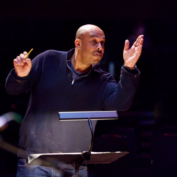 Desmond Oliver conducts at a music stand.