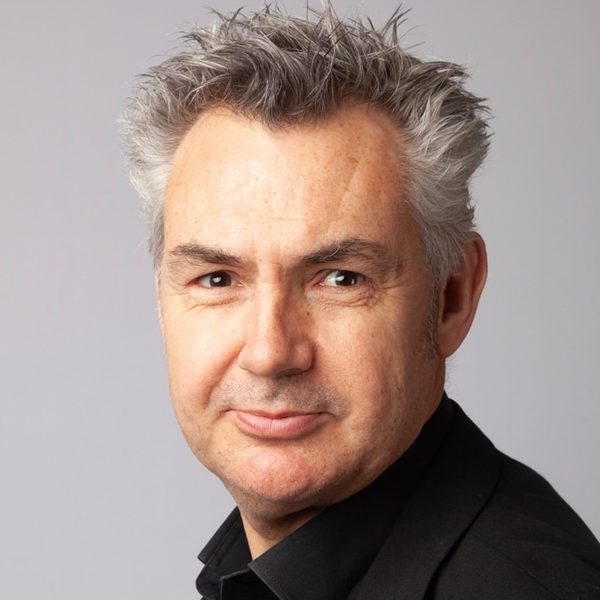 Dominic Hackett poses for photo against a grey background