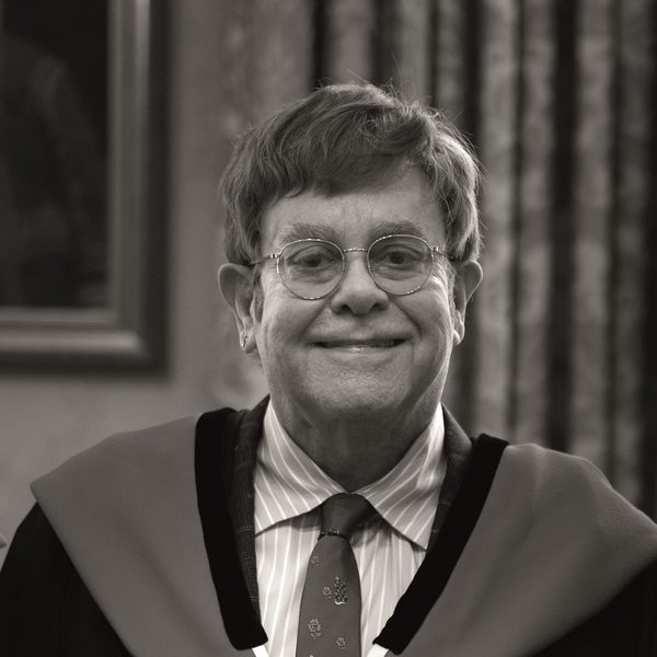 Elton John smiles to camera.