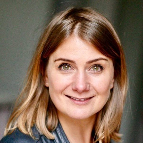 Eva Doroskoska faces camera, posing for headshot.