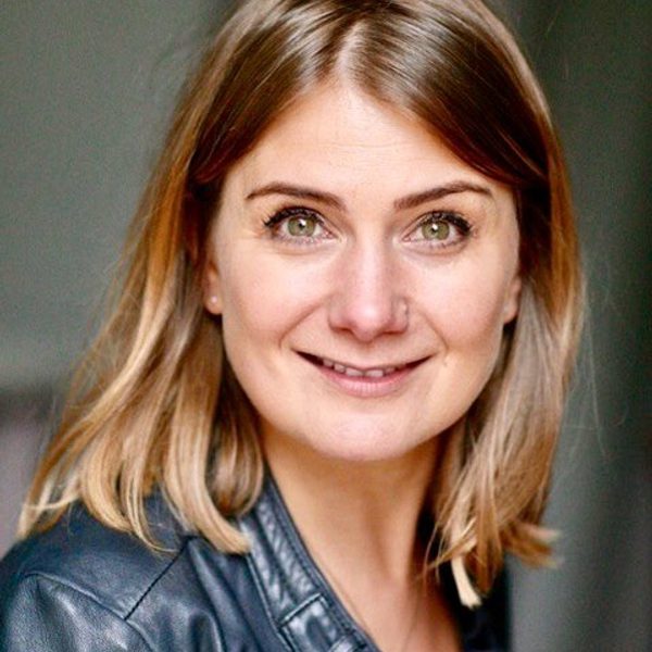 Eva Doroskoska faces camera, posing for headshot.