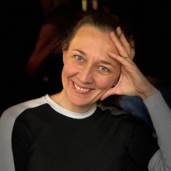 Fiona Harris sits, posing for headshot, smiling.
