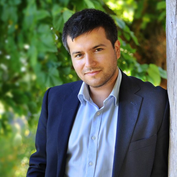 Florian Mitrea stands outside posing for a headshot.