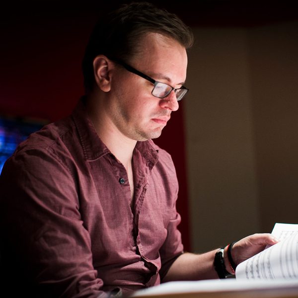 Gareth Coker sits reading manuscript.