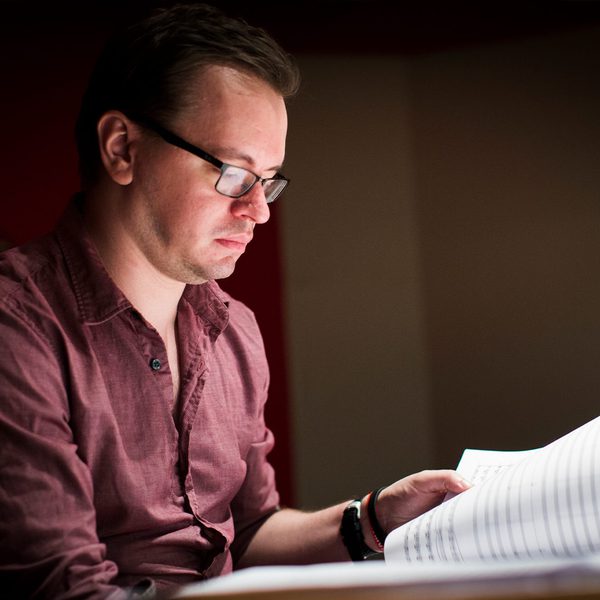 Gareth Coker sits reading manuscript.