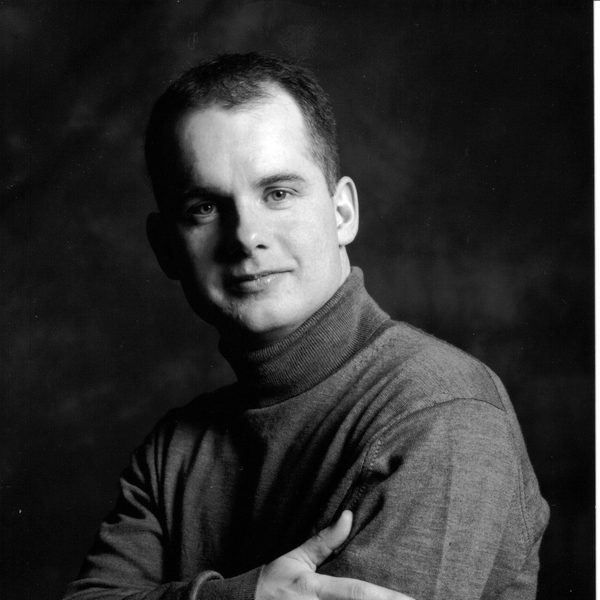 Black and white image of Graham Caskie posing for headshot.