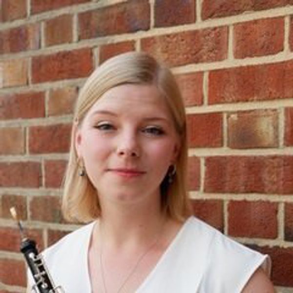Helena Mackie smiles to camera, holding clarinet.