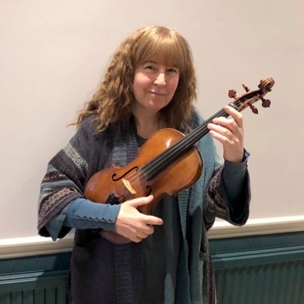 Jacky Woods holding a violin, smiling for camera