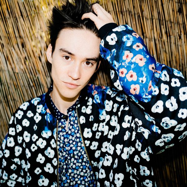 Jacob Collier Holds his hair, looking to camera