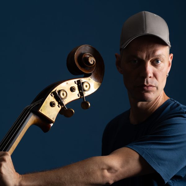 Portrait of Jasper Høiby indoors, holding a double bass