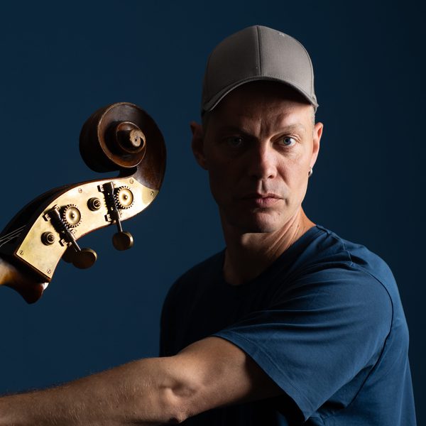 Portrait of Jasper Høiby indoors, holding a double bass.