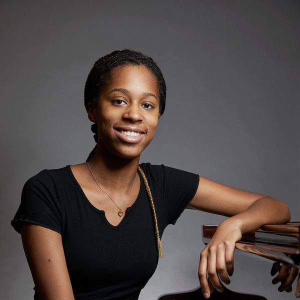 Jeneba Kanneh Mason sits at piano, smiling.