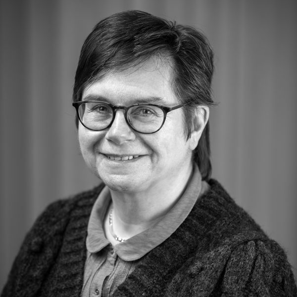 Portrait of Karen Di Lorenzo smiling to camera (black and white).