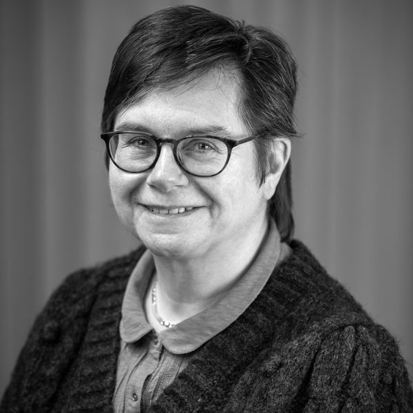 Portrait of Karen Di Lorenzo smiling to camera (black and white).