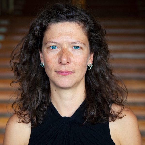 Kira Doherty stands at the bottom of a staircase, facing camera.