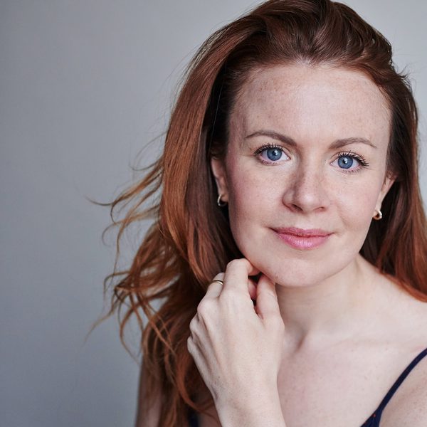Laura Tebbutt smiles to camera, hand on chin.