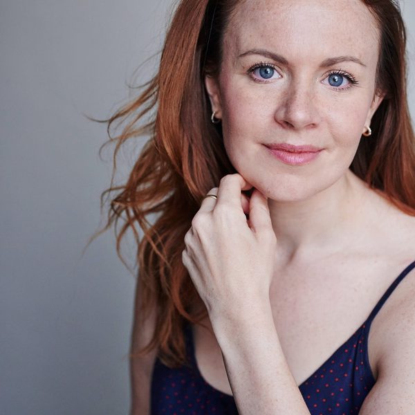 Laura Tebbutt smiles to camera, hand on chin.