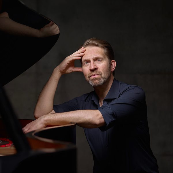 Leif Ove Andsnes Sits at a Piano, looking at camera.