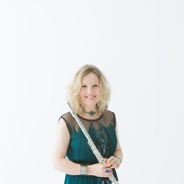 Lorna Mcghee holds a flute, smiling.